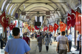 People walking in a market with Turkish flags on each side